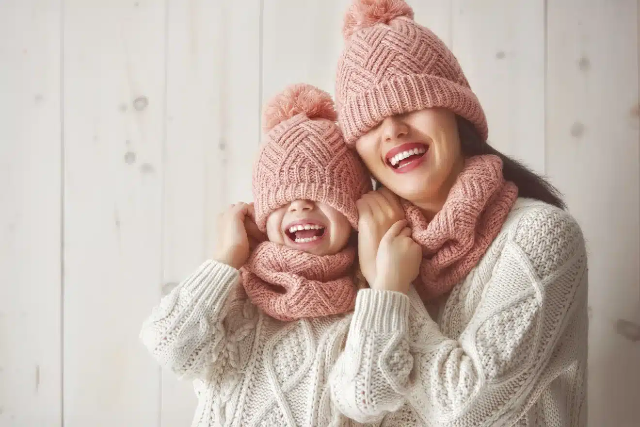 woman and girl having fun trying on hats and scarves