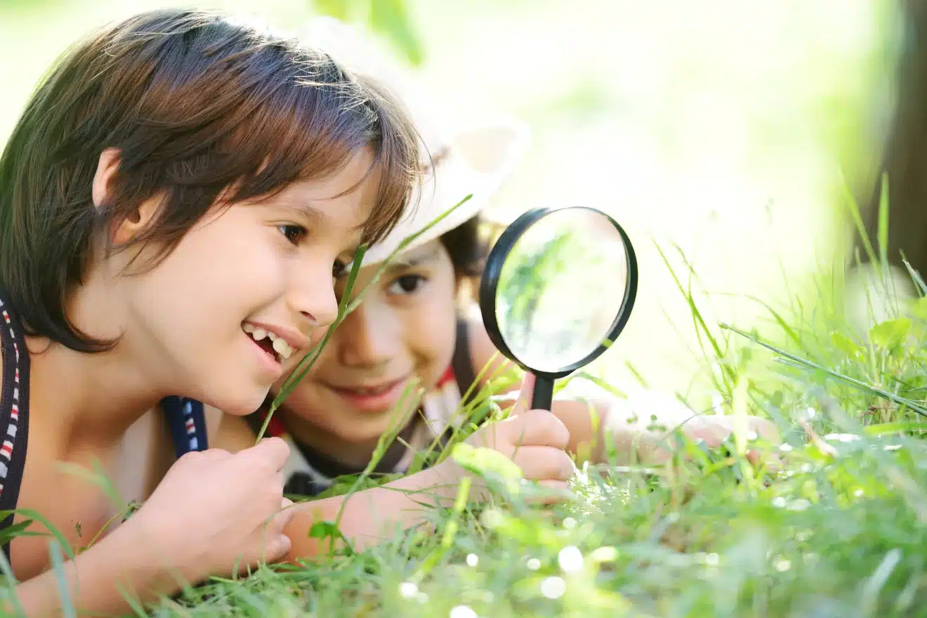 boys looking through a magnifying glass