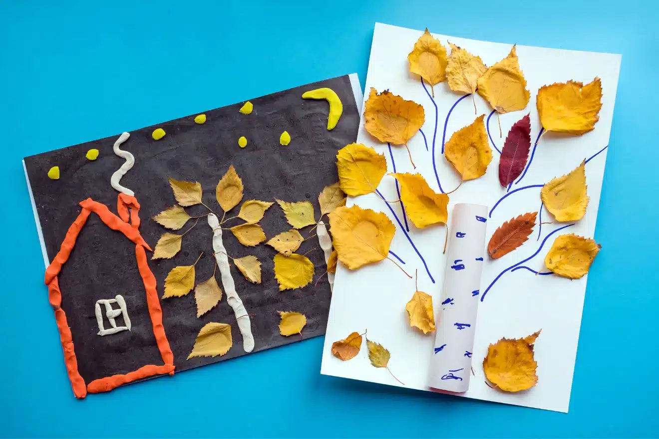Two children's art projects on a blue background: one depicts a night scene with a house, made with clay and leaves; the other is a tree with leaves attached to branches drawn in blue marker.