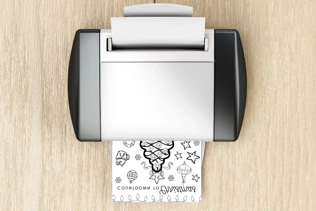 A printer on a wooden surface is printing a page with whimsical black line art illustrations and doodles.