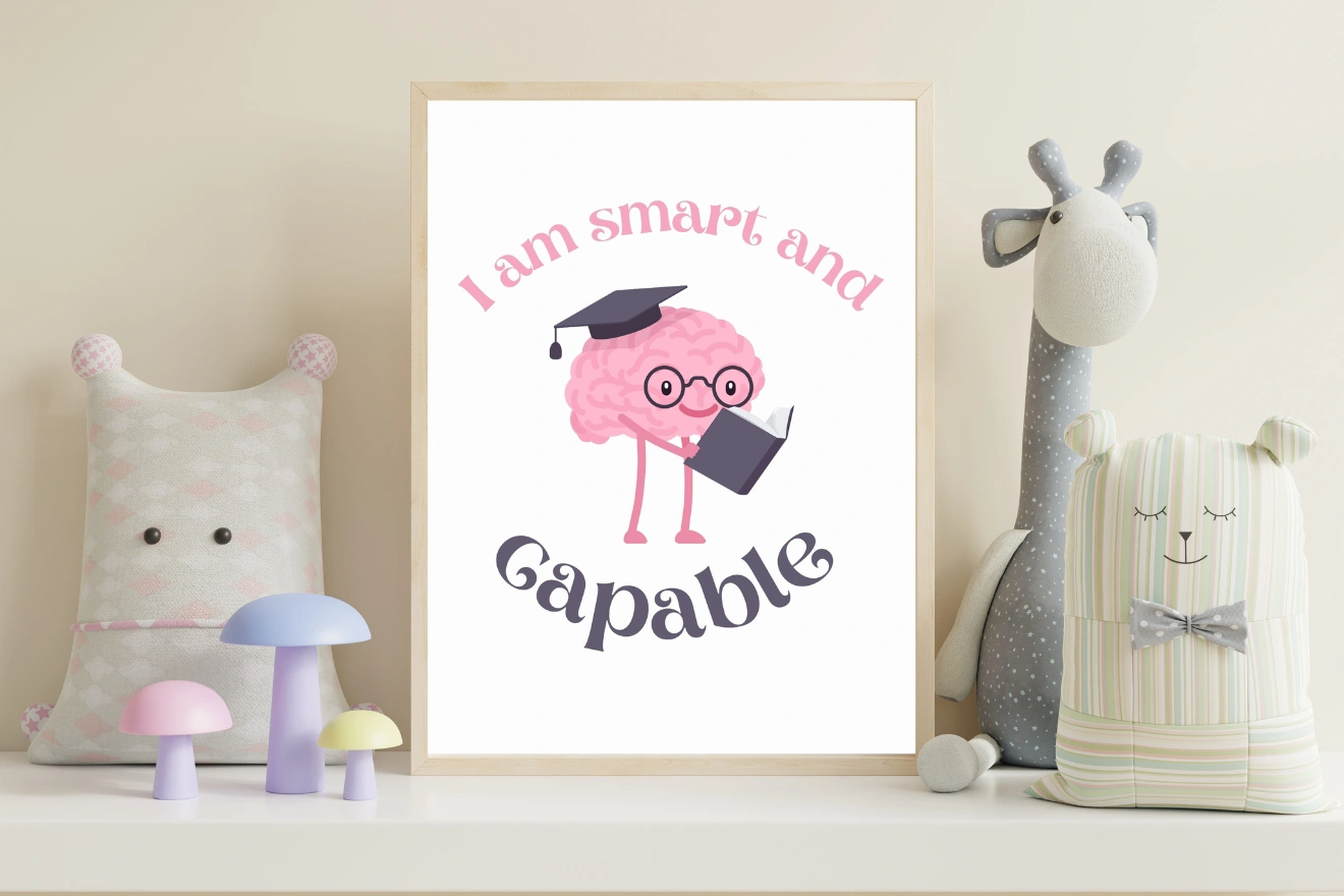 A framed art print features a cartoon brain with glasses and a graduation cap, holding a book. The text reads "I am smart and capable." It's placed on a shelf with stuffed toys and pastel mushroom decor.