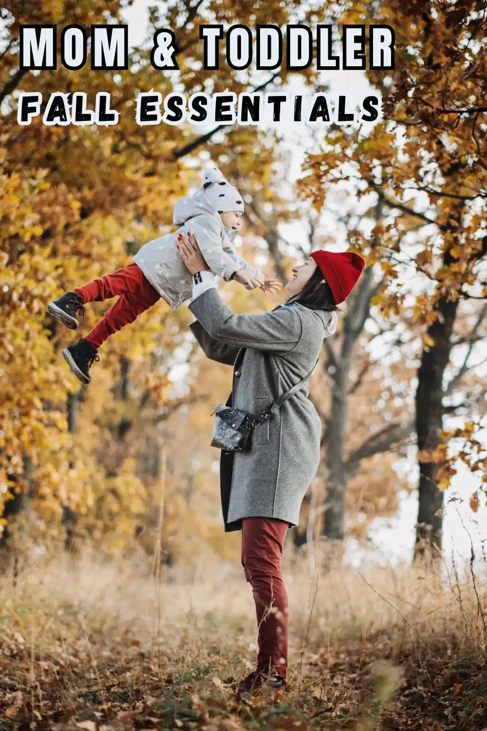 A woman in a gray coat and red hat lifts a toddler in autumn clothing among fall foliage, with text reading "Mom & Toddler Fall Essentials.