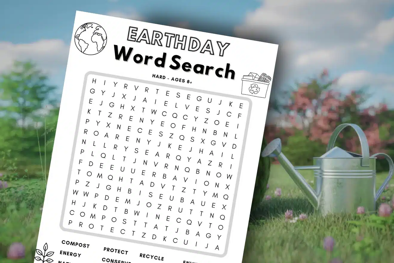 A printed Earth Day-themed word search puzzle is shown outdoors on grass, with a watering can and flowers in the blurred background.